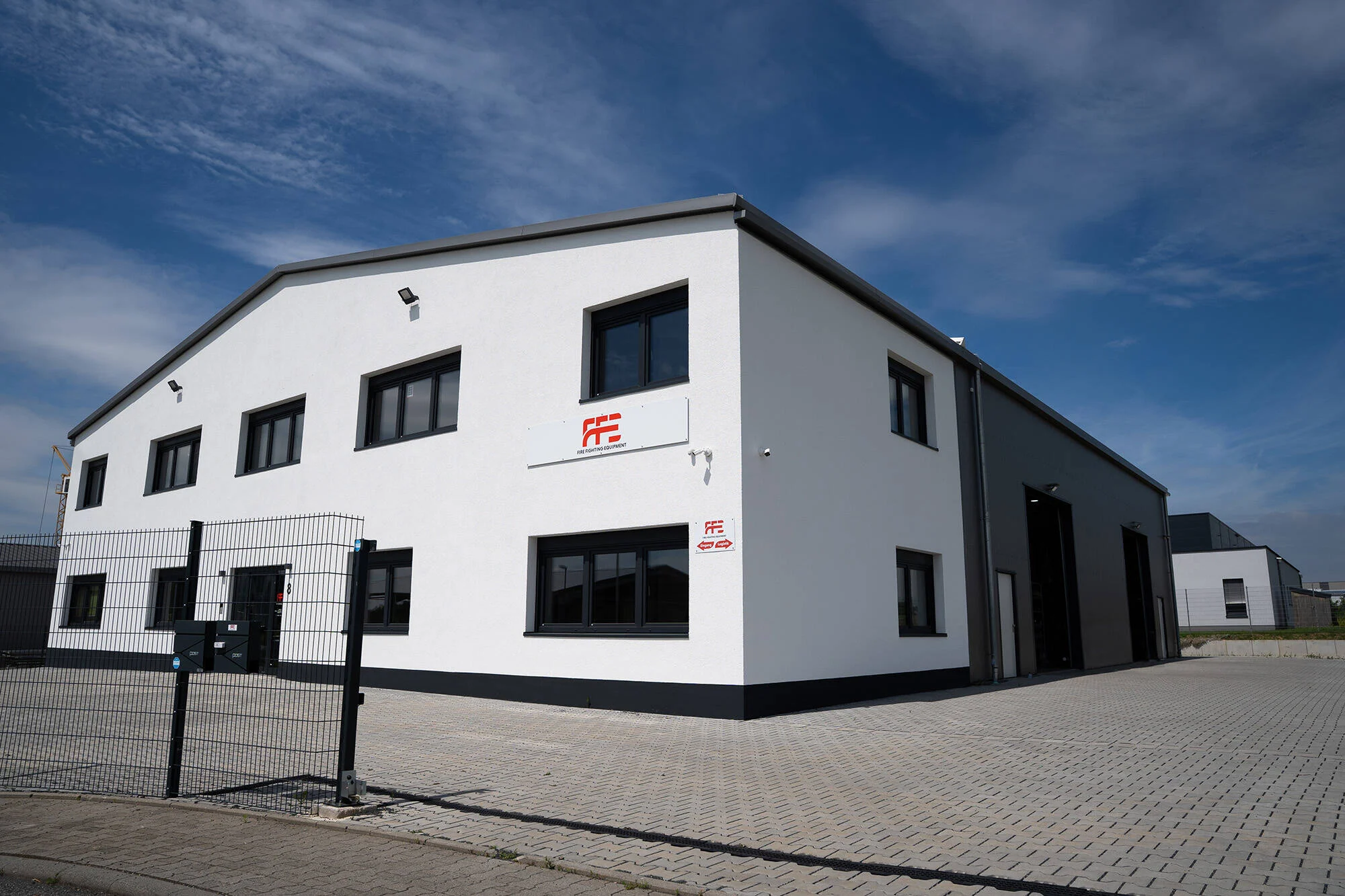 Firmengebäude der FFE GmbH in Hammersbach mit FFE-Logo an der Fassade unter blauem Himmel